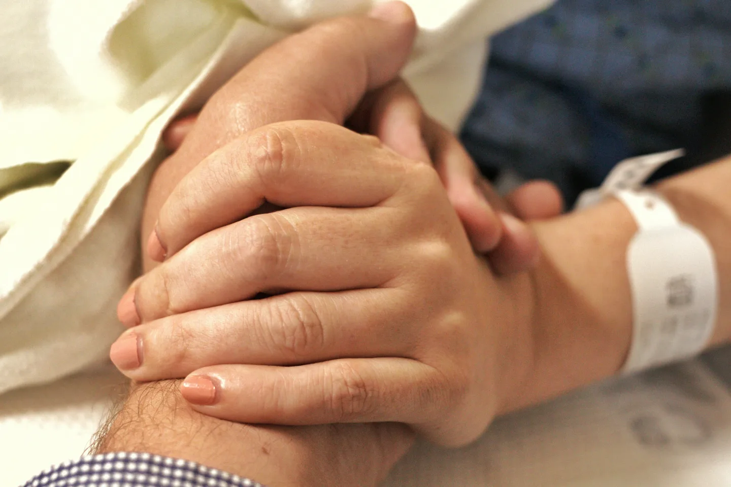 Caring hands holding a patient's hand