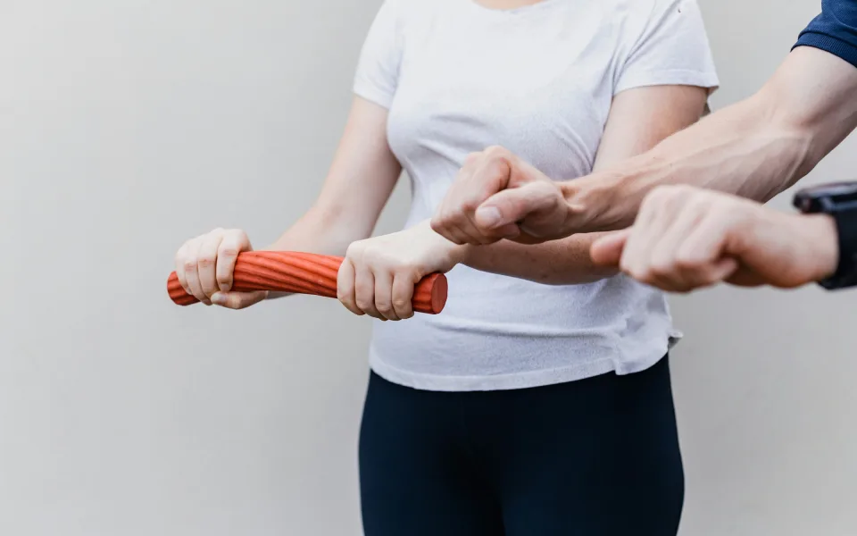 أخصائي علاج طبيعي يوجّه تمريناً بشريط المقاومة